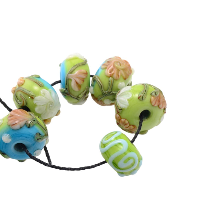 Lampwork glass beads set on black cord, lime green and blue floral beads
