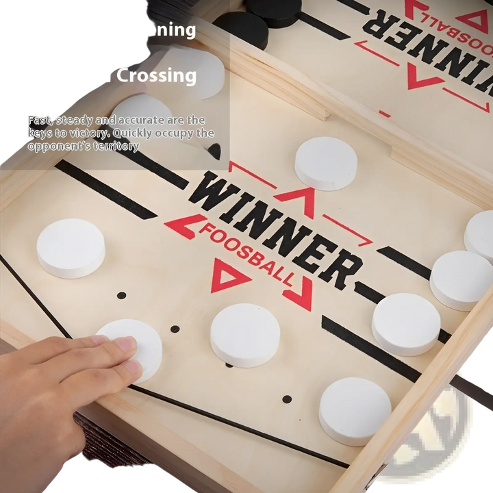 Close-up of desktop puck game board with white and black discs on wooden rails