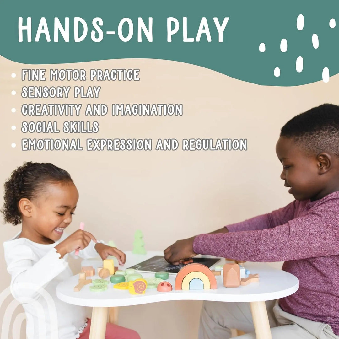 Wooden forest sensory bin on round table with wooden trees, animals and rainbow
