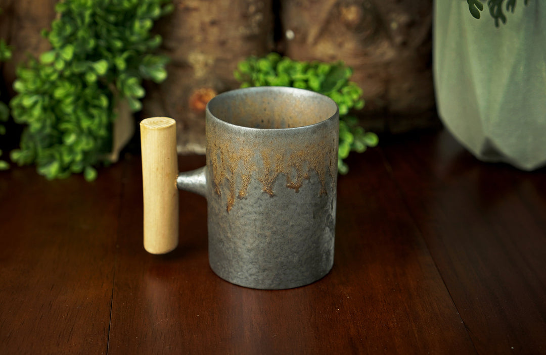 Glazed ceramic mug with wooden handle, speckled iron bronze glaze pattern
