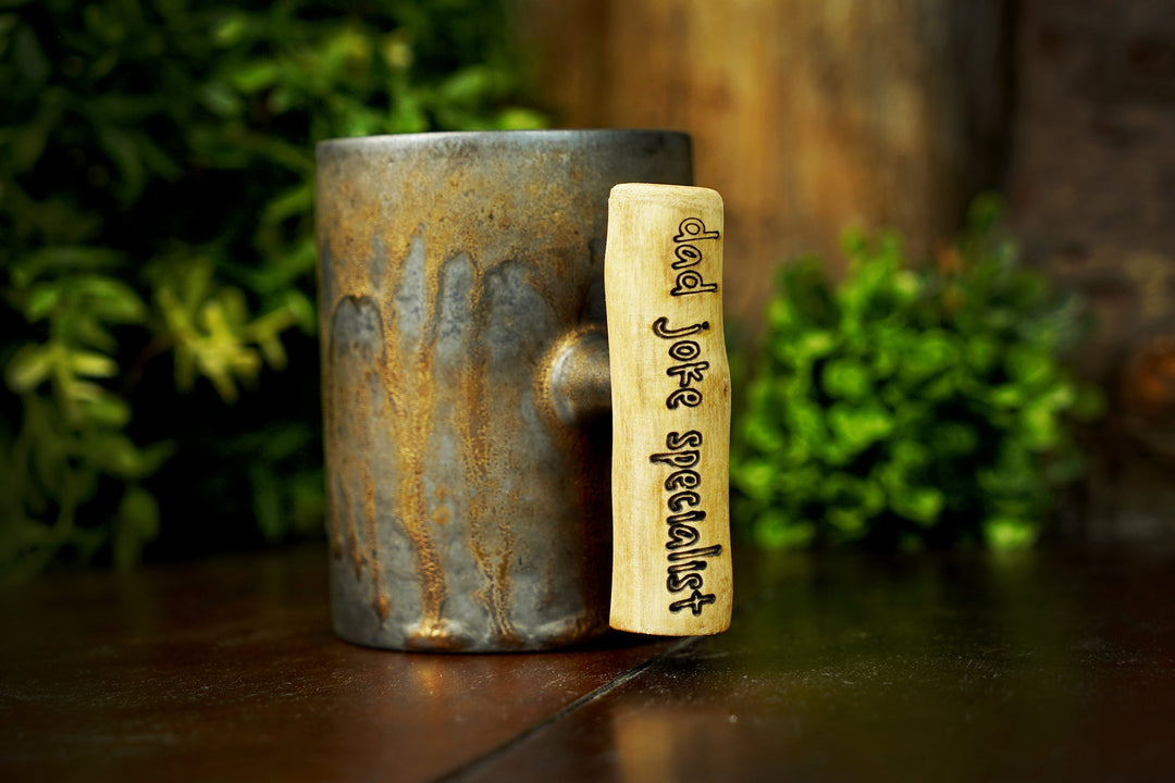 Glazed ceramic mug with engraved wooden handle, iron bronze speckled glaze