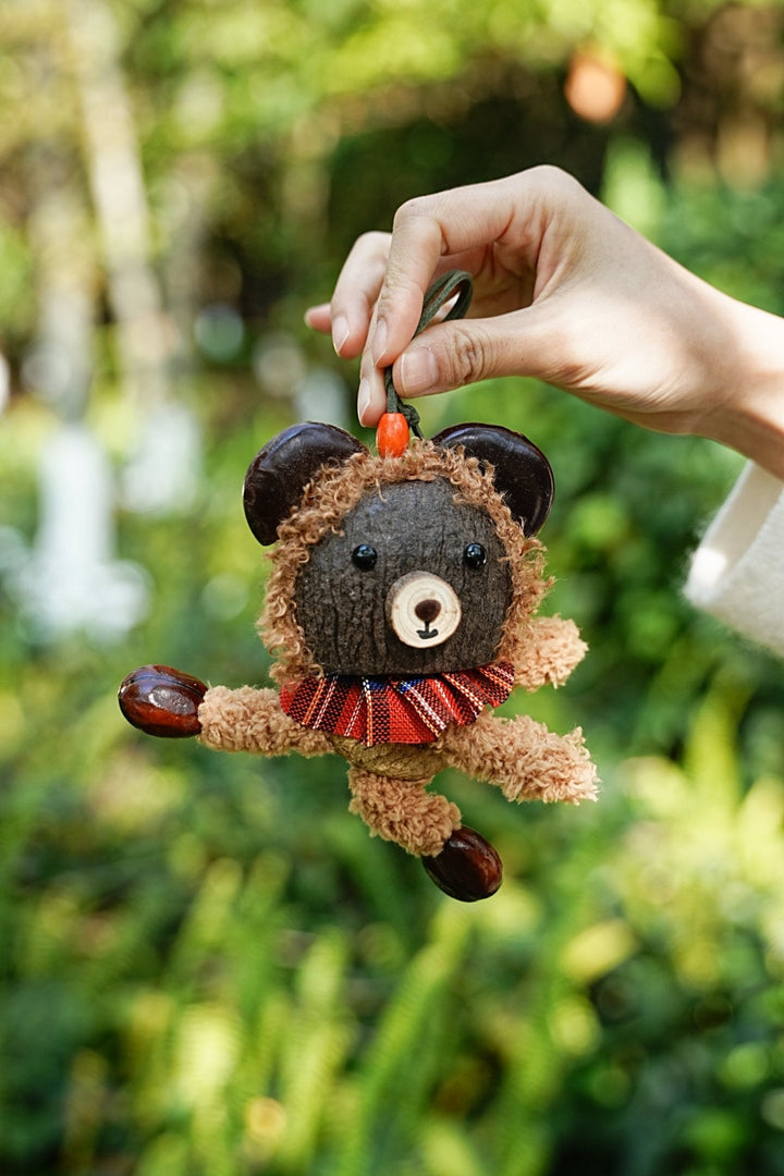 Plush teddy bear seed bag charm with red striped scarf and dangling feet