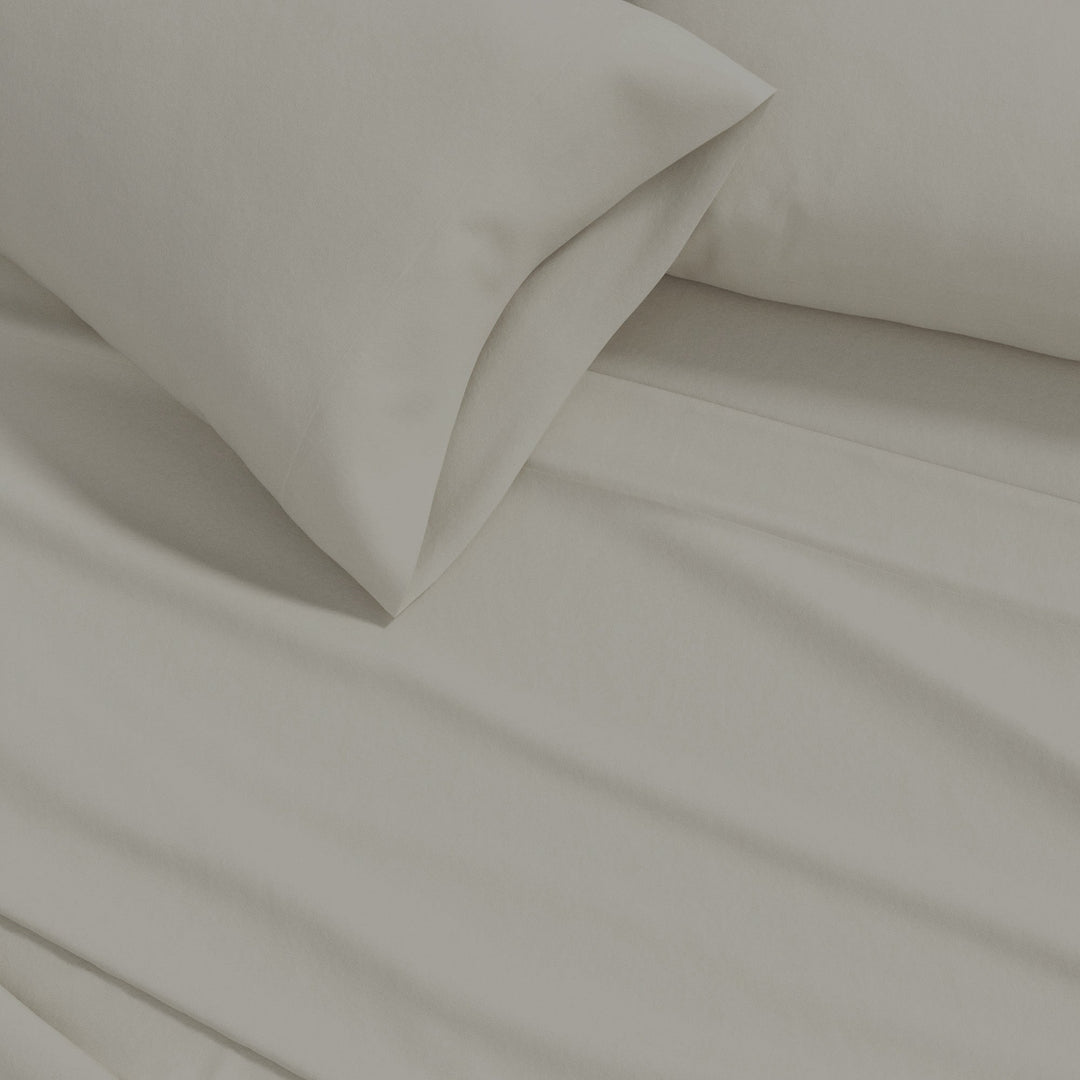 Cotton solid flannel sheet fabric close-up in warm off-white with soft folds