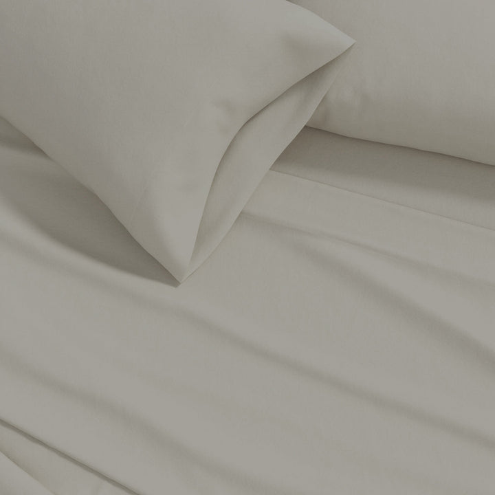 Cotton solid flannel sheet fabric close-up in warm off-white with soft folds