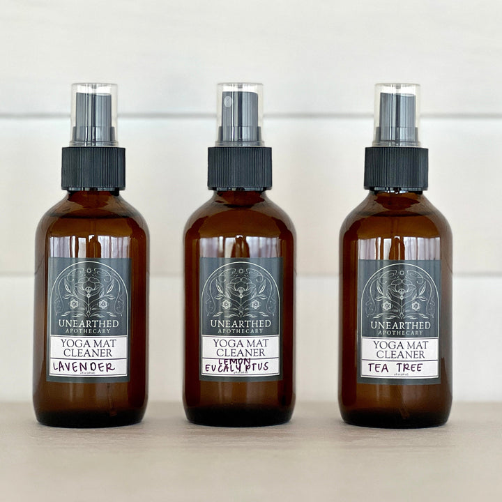 Yoga mat cleaning spray bottles, amber glass with black mist sprayer, three scents shown