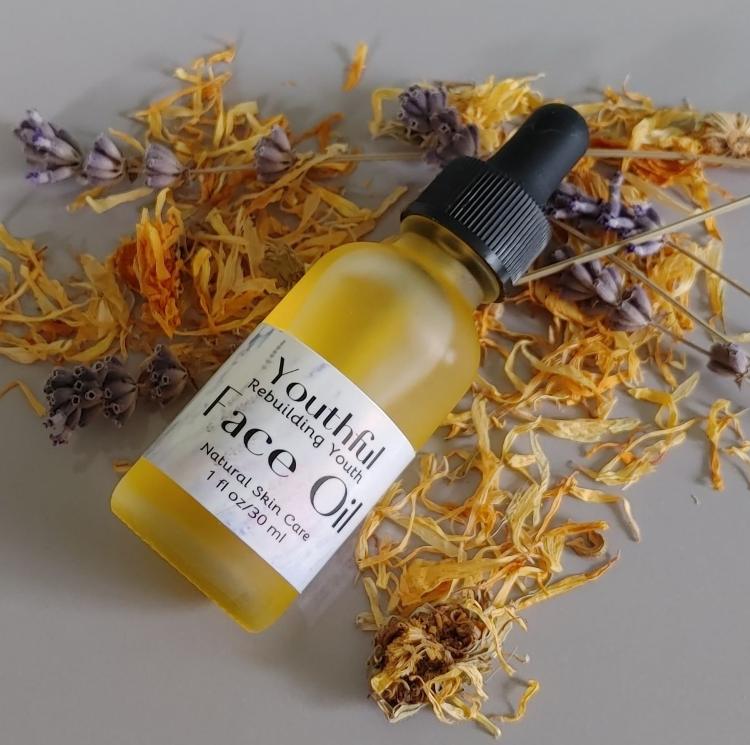 Face oil bottle with dropper on yellow and purple dried flowers