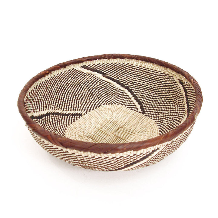 Round woven basket bowl in tan and dark brown with curved stripe and diamond motif