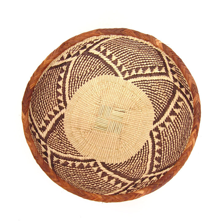 Round woven basket bowl in tan and dark brown with diamond and line motifs