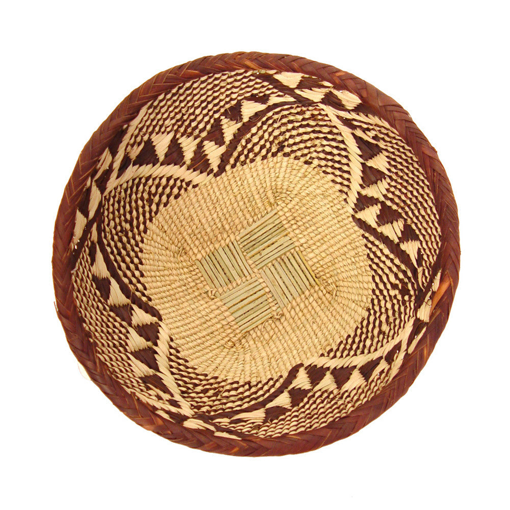 Round woven basket bowl in tan and dark brown with bold geometric border pattern