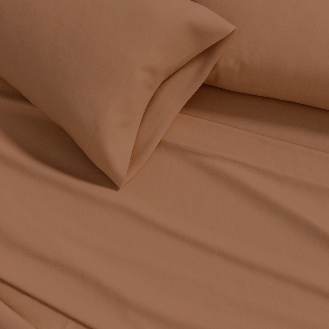 Cotton flannel sheet close-up in camel brown, smooth solid fabric texture